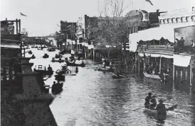  ?? California State Library 1861 ?? Boaters make their way down a flooded K Street in Sacramento in 1862.