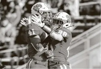  ??  ?? Davis celebrates his second-quarter score with Katy tight end Emilio Silva (41). The Tigers already were up 42-0 by halftime on their way to a record 15th state title game appearance.