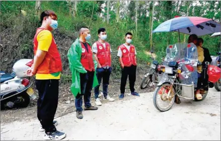  ?? AFP ?? Local volunteers guard a roadblock near the aircraft’s crash site at Langnan village in Wuzhou on Wednesday.