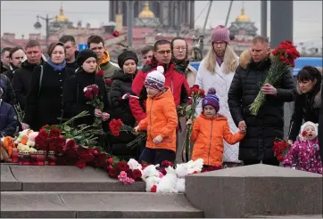  ?? DMITRI LOVETSKY — THE ASSOCIATED PRESS ?? People lay flowers at a spontaneou­s memorial in memory of the victims of Moscow attack, in St. Petersburg, Russia, on Sunday. Russia observed a national day of mourning on Sunday, two days after an attack on a suburban Moscow concert hall that killed over 130 people.