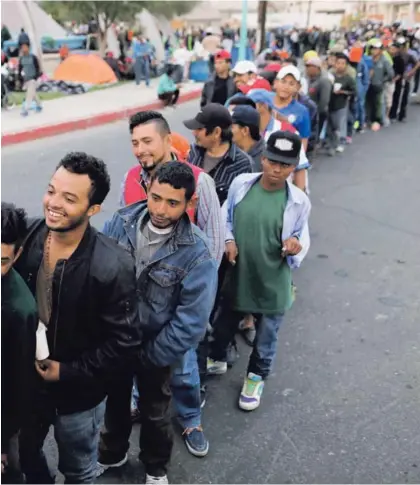  ?? AP ?? Miles de migrantes centroamer­icanos marchan desde el 13 de octubre hacia Estados Unidos en al menos tres caravanas. En la foto, un grupo esperaba para recibir cena en la ciudad fronteriza de Mexicali.