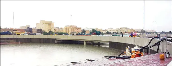 ?? Photo by Mohamed Morsi ?? A road under a bridge completely submerged by flood waters resulting from torrential rains which hit the country Friday night causing a lot of havoc including the death of a Kuwaiti citizen.