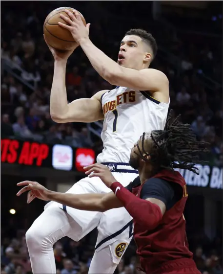  ?? RON SCHWANE — THE ASSOCIATED PRESS ?? Nuggets forward Michael Porter Jr. shoots against Cleveland Cavaliers guard Darius Garland during the second half on Thursday night in Cleveland.