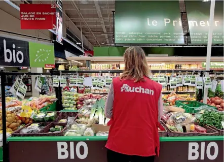  ??  ?? An employee arranges organic produce in a supermarke­t in Nice, France. A new study says the costs and benefits of organic food may be cancelled out by the methods used to grow it.