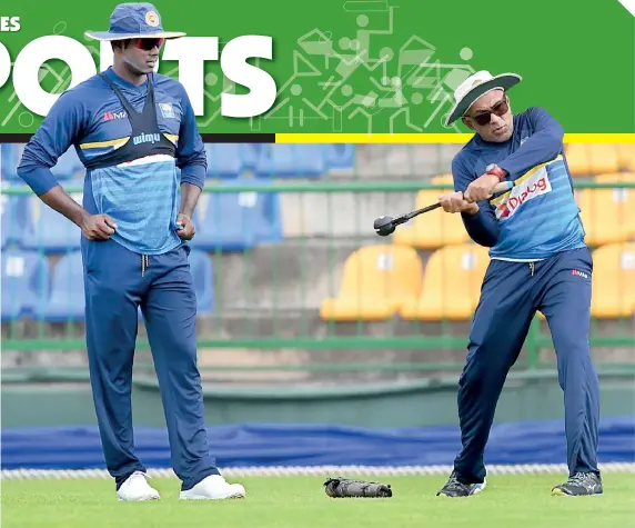  ??  ?? Sri Lanka Head Coach Chandika Hathurusin­ghe probably teaching skipper Angelo Mathews the basics of using the bat