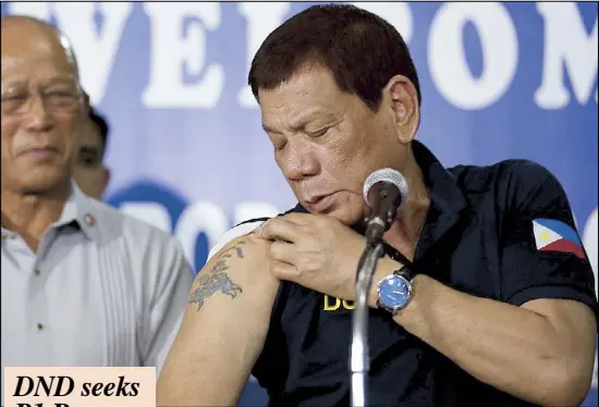  ??  ?? Amid claims by Sen. Antonio Trillanes IV that his son has a triad tattoo, President Duterte shows reporters a rose tattoo on his arm during a visit to a military hospital in Cagayan de Oro City yesterday. Looking on is Defense Secretary Delfin Lorenzana.