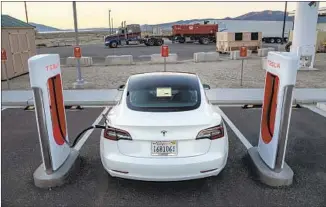  ?? Robert Gourley Los Angeles Times ?? FILL ’ER UP — with a full charge, that is, as the Tesla 3 stops for a jolt in Hawthorne, Nev.