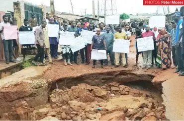  ?? PHOTOS: ?? Protesters at a portion of the collapsed road
Peter Moses