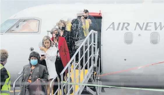  ?? Photo / Michael Craig ?? Passengers wearing masks disembark the flight from Auckland to Gisborne yesterday.