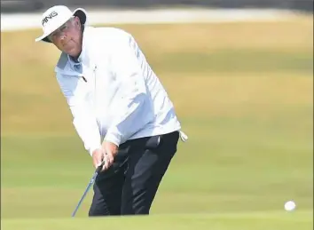  ?? Tony Marshall/Getty Images ?? Kirk Triplett putts on the 17th green on the first day of The Senior Open Thursday at The Old Course in St Andrews, Scotland. Triplett, of the United States, shot a 7-under 65 and is tied for the lead.