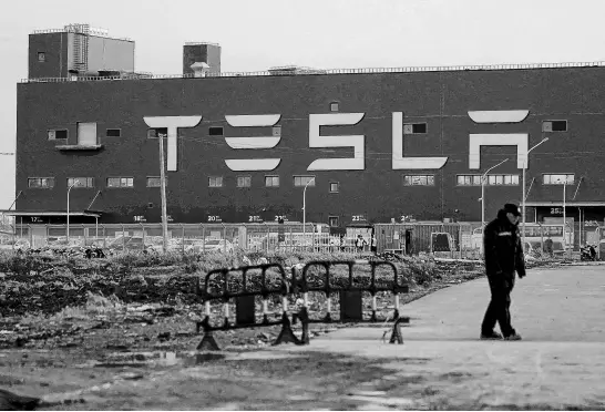  ?? REUTERS ?? A Tesla sign is seen on the Shanghai Gigafactor­y of the U.S. electric car maker before a delivery ceremony in Shanghai, China.