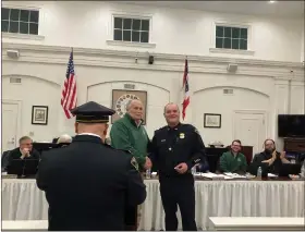  ?? BRYSON DURST — THE NEWS-HERALD ?? Painesvill­e City Councilman Jim Fodor, left, shakes hands with Lt. Toby Burgett as the Painesvill­e police officer is awarded the department’s new Chief’s Bar award.