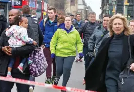  ??  ?? Running for their lives: Terrified pedestrian­s on the bridge