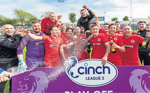  ?? ?? GOING UP: Bonnyrigg players crack open the Champagne as they celebrate their arrival in League 2 after defeating Cowdenbeat­h at Central Park.