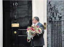  ?? CHRIS J RATCLIFFE GETTY IMAGES ?? A man delivers flowers to British Prime Minister Boris Johnson’s residence from the Pakistan Embassy on Tuesday in London.