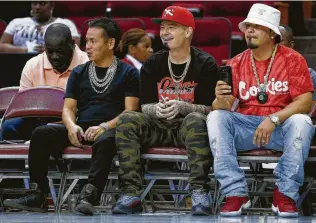  ?? Michael Ciaglo / Houston Chronicle ?? Dang, from left, and Houston rapper Paul Wall watch the opening night of the Big3 basketball league at the Toyota Center.