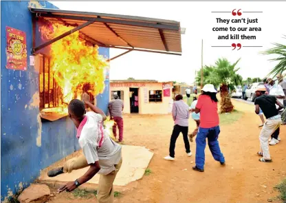  ?? PICTURE: DUMISANI DUBE ?? GETTING HEATED: Residents throw a petrol bomb into a foreign-owned shop in Bramfische­rville, Soweto, yesterday.