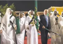  ?? Anadolu Agency / Getty Images ?? King Salman (second from left) and President Trump join a saber dance at the palace.