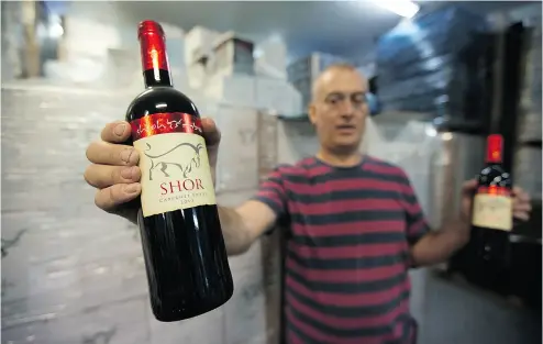  ?? MENAHEM KAHANA / AFP / GETTY IMAGES FILES ?? Amichai Luria with bottles of his wine at the Shilo winery in the occupied West Bank. The CFIA has reversed a decision that initially told wine sellers it was unacceptab­le to label Israel as the country of origin for West Bank wines.