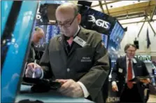  ?? RICHARD DREW — THE ASSOCIATED PRESS ?? Trader Andrew Silverman, center, works on the floor of the New York Stock Exchange, Tuesday.