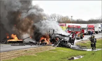  ?? BILL LACKEY / FILE ?? Members of the Mad River Township fire department extinguish the flames that consumed a tractor trailer and car after they collided head-on in 2015 on eastbound I-70 near the Enon Road entrance. The driver of the car was killed in the crash, but the truck driver escaped before it caught fire.