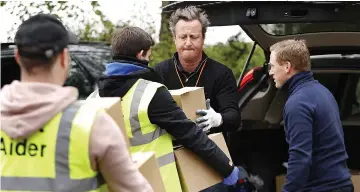  ?? Pictures: GETTY, HYDE NEWS AND REX ?? Holding the fort at home... former prime minister David Cameron and wife Samantha and, right, delivering food parcels during lockdown