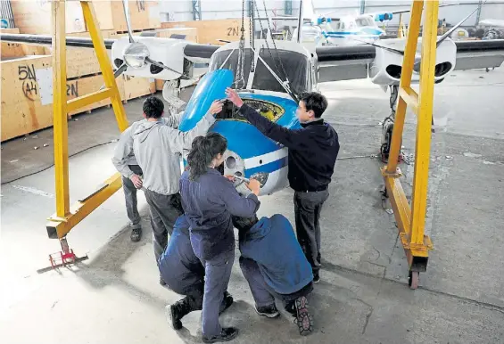  ?? J. FOGLIA ?? Taller. Estudiante­s de la escuela técnica 7 de Quilmes, especializ­ada en aeronáutic­a, trabajan ayer en la reparación de un tren de aterrizaje.