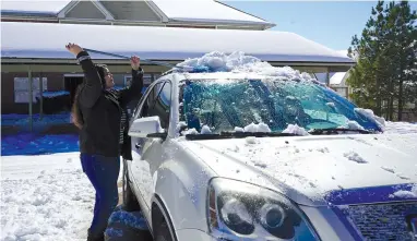  ?? The Sentinel-Record/Cassidy Kendall ?? Safari Hall, of Hot Springs, clears snow from her vehicle with a broom on Friday.