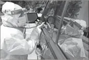  ?? Ap-curtis Compton ?? Walmart pharmacist Shama Sarangi times a motorist doing a self swab to ensure a good sample at a new mobile COVID-19 drive-through testing site to serve rural stretches of Georgia in communitie­s without access to testing at Diamond Lakes Regional Park in Hephzibah near Augusta. The mobile unit will travel between Augusta (Hephzibah), Milledgevi­lle, and Tifton on a rotating basis.