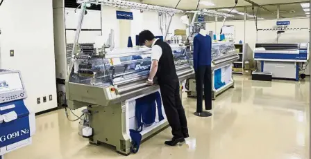  ??  ?? New venture: An employee checks a sweater being knitted by a whole-garment knitting machine inside the design centre at Shima Seiki headquarte­rs in Wakayama. The company is in talks with auto-parts makers to use its technology to develop lighter,...