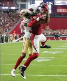  ?? RICK SCUTERI — THE ASSOCIATED PRESS ?? Arizona’s Larry Fitzgerald (11) pulls in the game-winning touchdown pass in front of San Francisco cornerback Rashard Robinson during overtime of Sunday’s game in Glendale, Ariz.