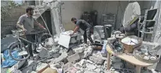  ?? AFP ?? Abu Abdullah (centre), a Syrian returning to Khan Sheikhoun in Idlib, inspects his destroyed home