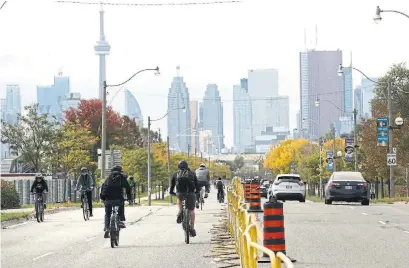  ?? RICHARD LAUTENS TORONTO STAR ?? Cyclists make their way along the reserved portion of Lakeshore Boulevard on Saturday. The popularity of ActiveTO road closures and the Quiet Streets program shows the need to keep encouragin­g outdoor activity as winter approaches, Shawn Micallef writes.