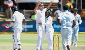  ??  ?? Job done: South African bowler Kyle Abbott (second from left) hugs teammate Temba Bavuma after dismissing Sri Lanka batsman and captain Angelo Mathews (left) in the fifth and last day of the first Test at the Port Elizabeth cricket ground yesterday.