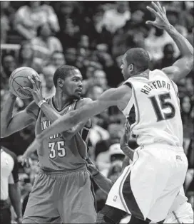  ??  ?? Thunder forward Kevin Durant looks to pass around Hawks center Al Horford during the first half in Atlanta. Durant’s 41 points set a season high as Oklahoma City avenged a November home loss against Atlanta.