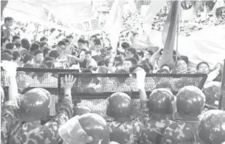  ?? AFP PHOTO ?? Security officers reinforce barriers as people hold Chinese flags and banners during an anti-Japanese protest outside the Japanese embassy over the Diaoyu islands which are known as the Senkaku islands in Japanese.