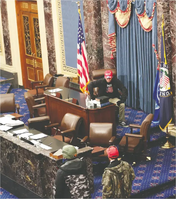  ?? Win Mcnamee / Getty Images ?? Pro-trump rioters stormed the U. S. Capitol as lawmakers were set to sign off Wednesday on President- elect Joe Biden’s victory. The protesters, who
had gathered on the Mall for a Trump rally, entered the Senate (above) and were stopped at gunpoint from breaking into the House (bottom).