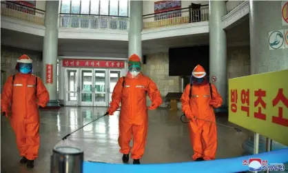  ?? Photograph: KCNA/EPA ?? Staff disinfect Pyongyang train station during North Korea’s campaign against Covid. It now has reported a total of 2.2 million people with fever, state media says.