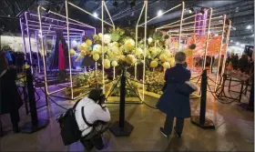  ?? AP PHOTO/MATT ROURKE ?? In this file photo, visitors view an exhibit during a preview of the 2019 Philadelph­ia Flower Show at the Pennsylvan­ia Convention Center in Philadelph­ia, Friday, March 1, 2019.