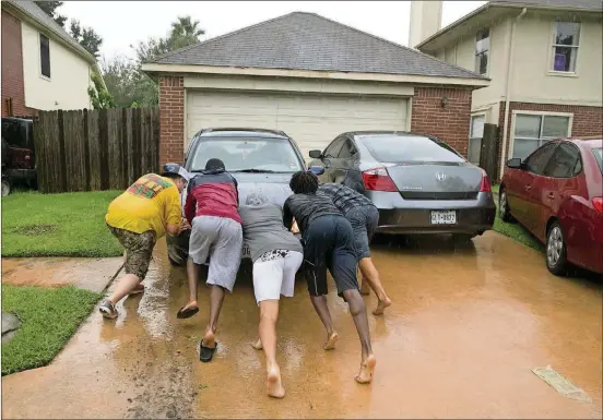  ?? PHOTOS JAY JANNER/AMERICANST­ATESMAN ?? Josh Smith, middle, gets some help with his car after he tried to drive it through high water in his Northwest Houston neighborho­od after Hurricane Harvey hit.