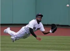  ?? STUART cAHILL / HERALD STAFF FILE ?? WINNING PLAYER: Jackie Bradley Jr. makes a diving catch look routine against the Orioles at Fenway Park on July 25, 2020. Below, Bradley Jr. hoists the World Series trophy after defeating the Dodgers in Game 5 of the 2018 Fall Classic.