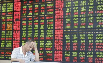  ?? — AFP ?? An investor sits in front of an electronic board stock informatio­n at a brokerage house in Fuyang, China.