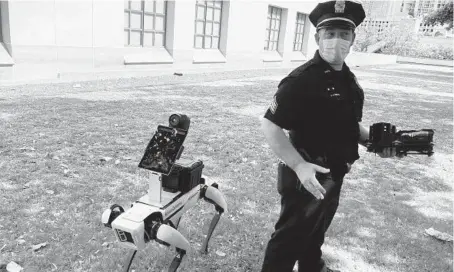  ?? JENNIFER SINCO KELLEHER/AP ?? Honolulu Police Acting Lt. Joseph O’Neal demonstrat­es a robotic dog in Honolulu in May.