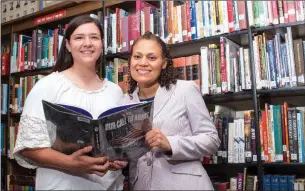  ?? WILLIAM HARVEY/THREE RIVERS EDITION ?? Harding Academy freshman Carson McFatridge, left, and Harding Academy social-studies teacher Angela Adams look at the Life magzine book Our Call to Arms: The Attack on Pearl Harbor in the school library. McFatridge and Adams have been invited to...