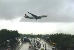  ??  ?? MUMBAI: An aircraft of India’s Jet Airways lands during rain showers yesterday. —AFP