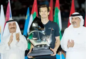  ??  ?? Andy Murray, flanqueado por el sheik Hashar bin Maktoum Al-Maktoum (izq.) y Salah Tahlak, sostiene el trofeo de campeón.