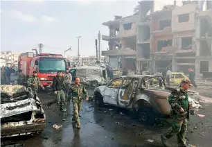  ?? AFP ?? Citizens gather at the scene of where two blasts exploded at Al Zahrra area in Homs province. —