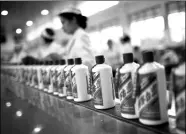  ?? BLOOMBERG ?? Workers oversee baijiu bottling at China Kweichow Moutai Distillery Co’s plant in Guizhou province. The company’s shares surged 150 percent this year before retreating.