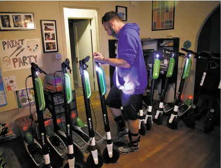  ?? Photos by Josie Lepe / Special to The Chronicle ?? David Padover lines up scooters from companies including Lime and Bird for charging in his San Jose living room.