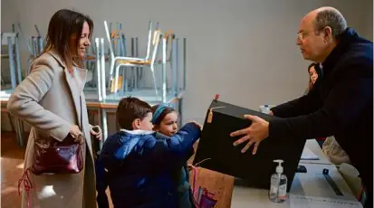  ?? ARMANDO FRANCA/ASSOCIATED PRESS ?? A woman and her children put her vote in the ballot box at a polling station in Lisbon on Sunday. Public frustratio­n with politics-as-usual has been percolatin­g among voters.